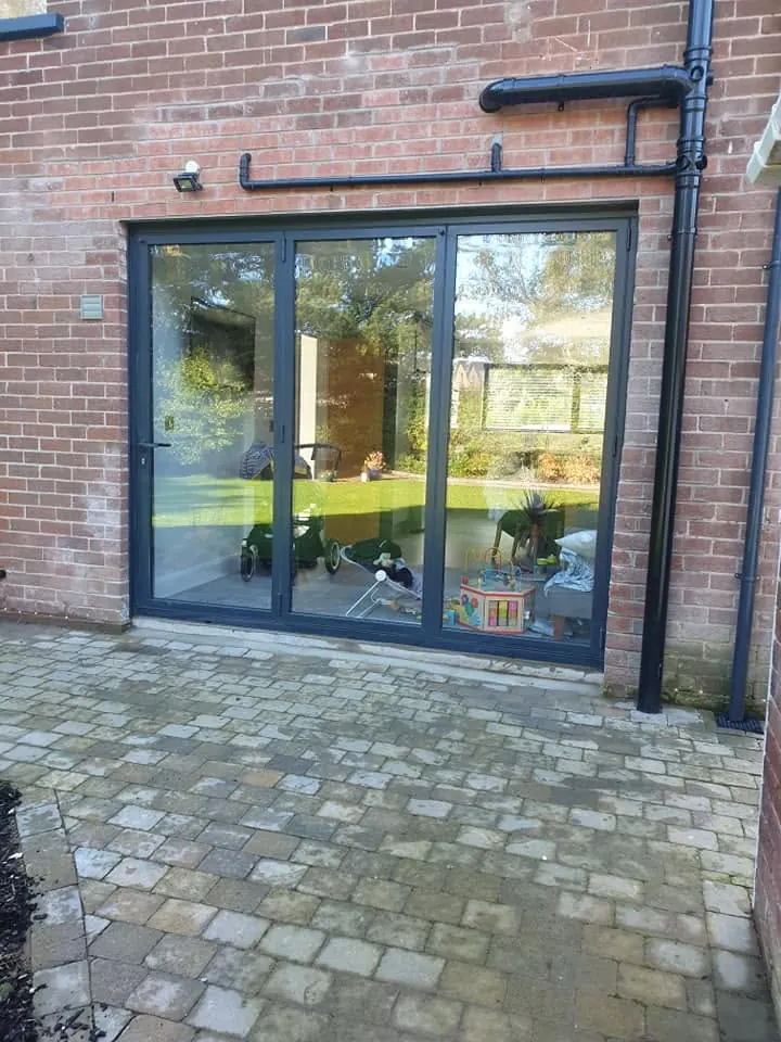 Aluminium bi-fold doors fitted in a brick rear elevation