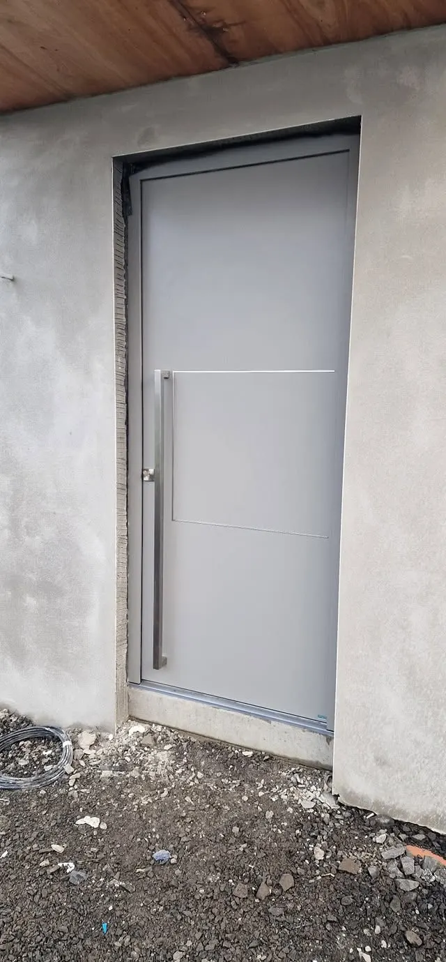 Light grey solid aluminium front door with vertical bar handle