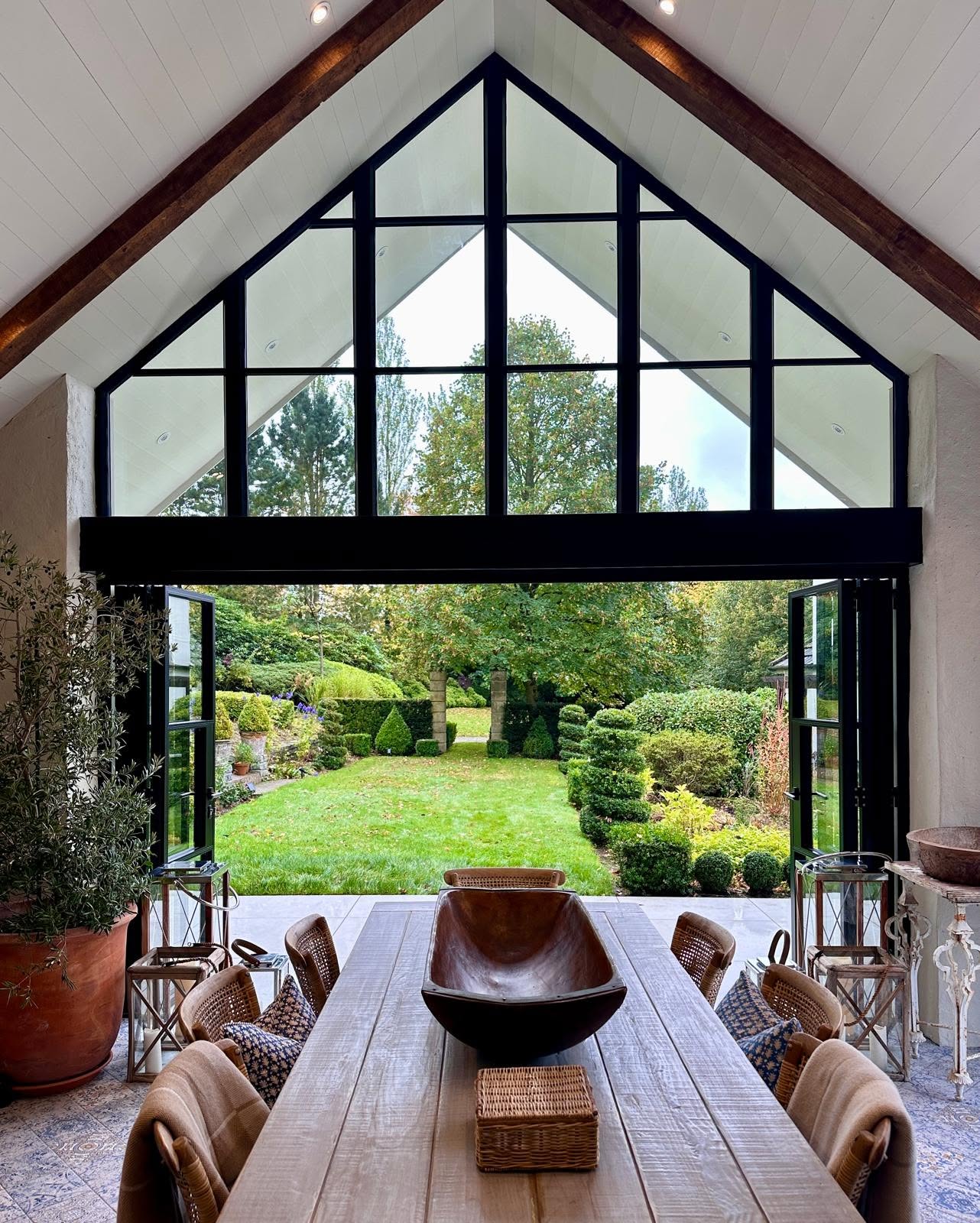 Glazed gable seen from inside over a dining table and garden