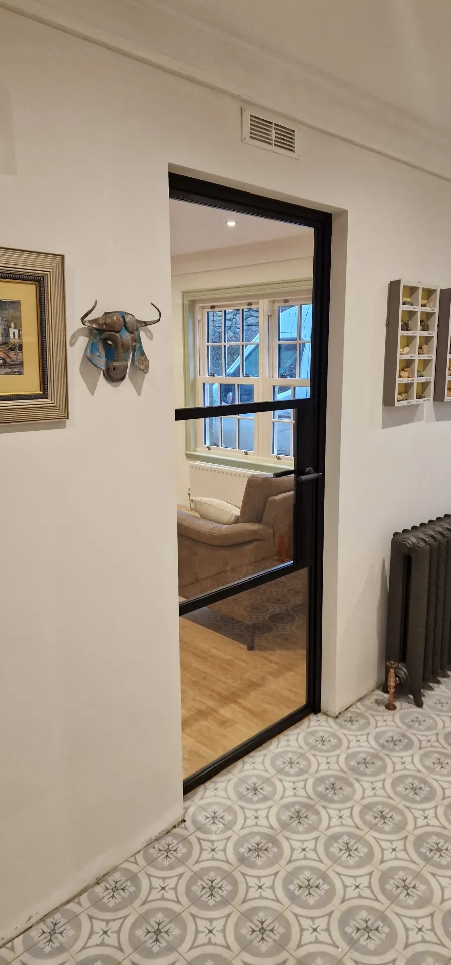 Steel-look internal door with two glazing bars off a tiled hallway