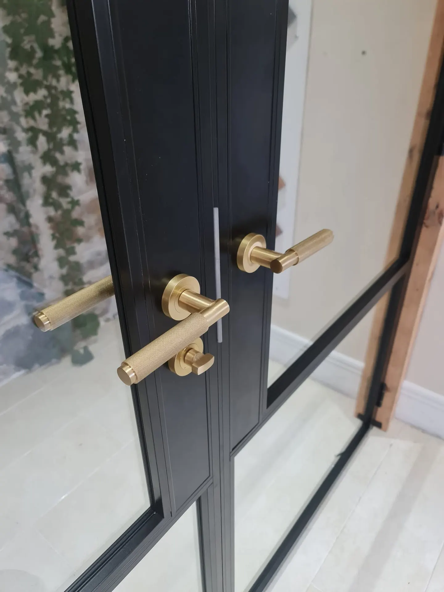 Close-up of brass handles on black steel-look internal doors