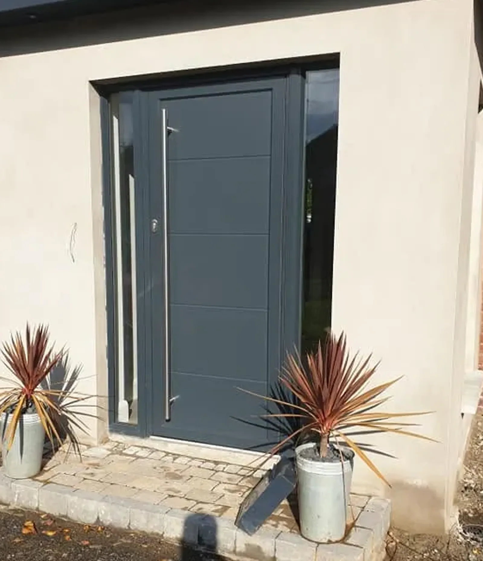 Grey aluminium front door with full-height bar handle and glazed side panels, Northern Ireland