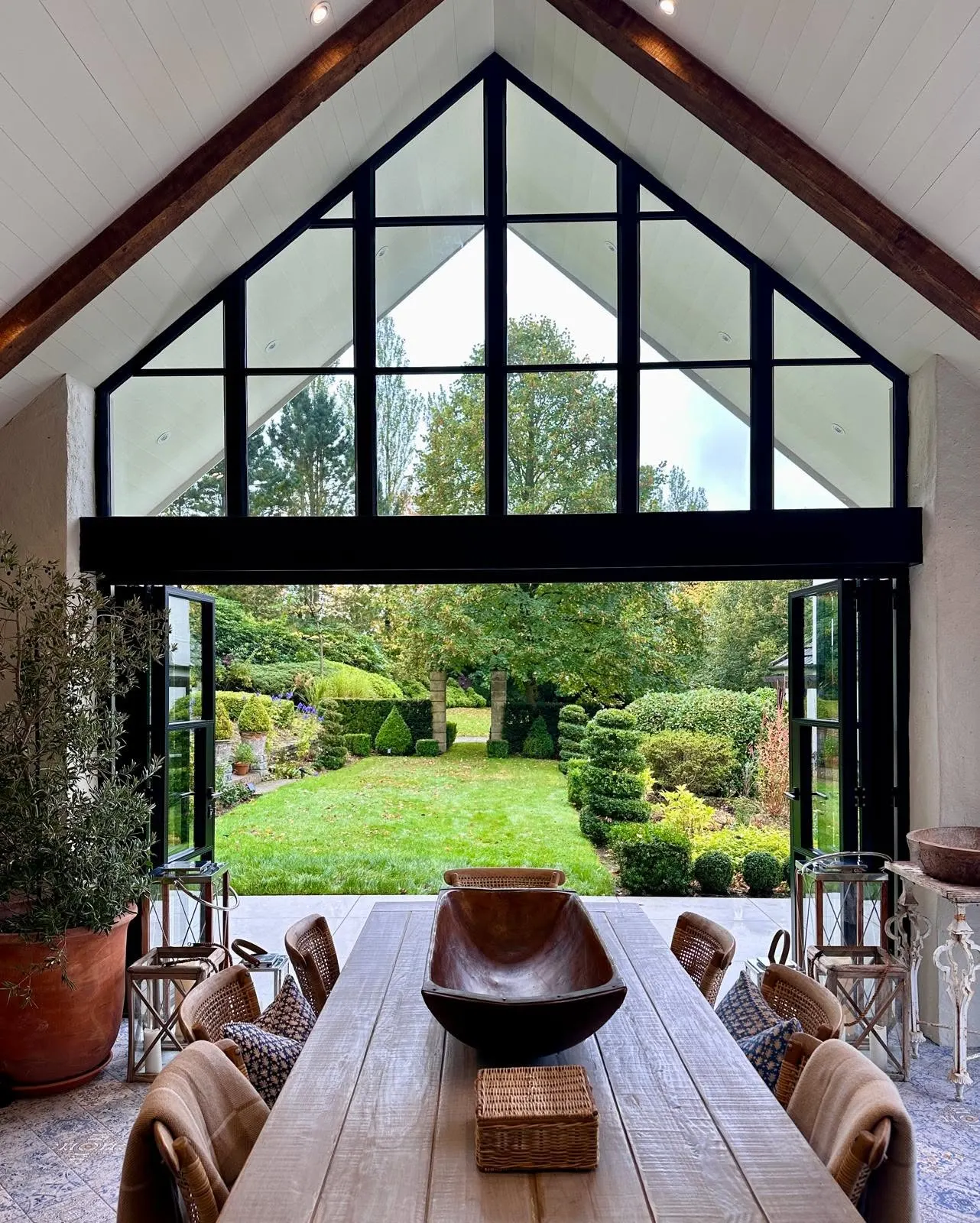 Glazed gable seen from inside over a dining table and garden