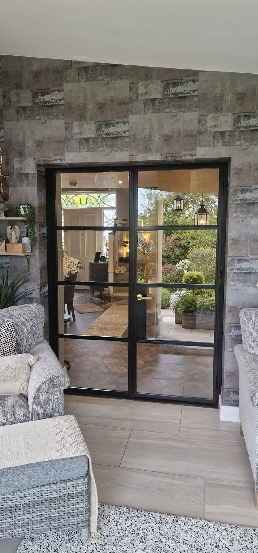 Black glazed aluminium French doors with brass handle opening into a hallway, Northern Ireland