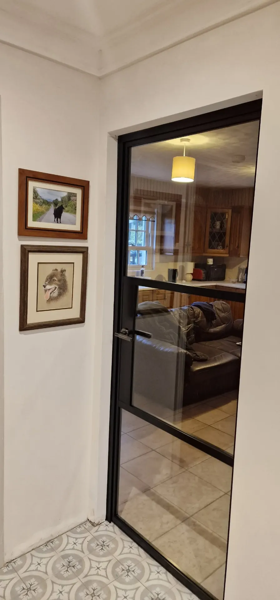 Single black glazed internal door to a kitchen and living area