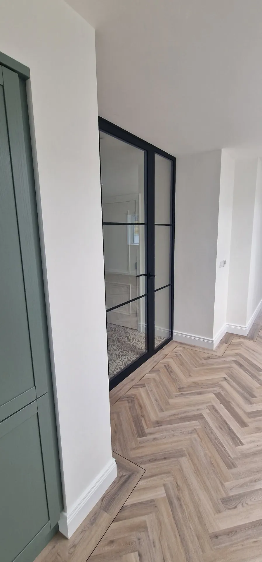 Black steel-look internal door and side panel seen from the kitchen