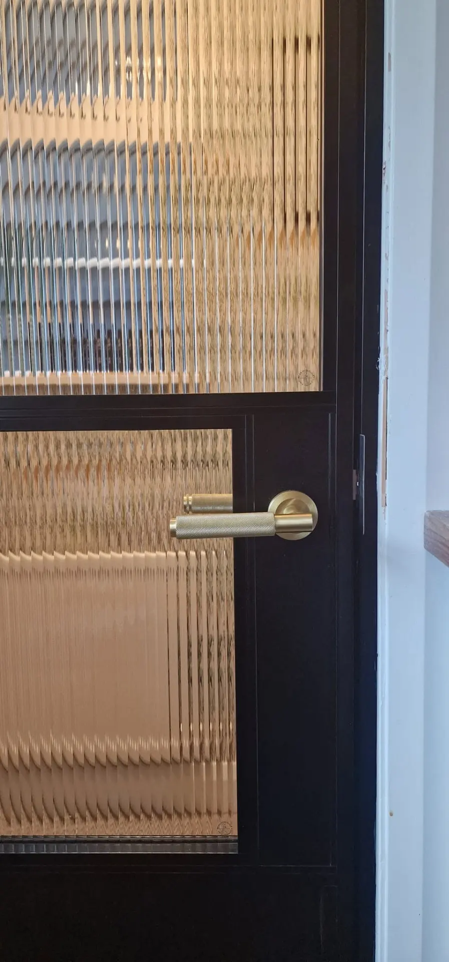 Steel-look internal door with reeded glass and brass handle