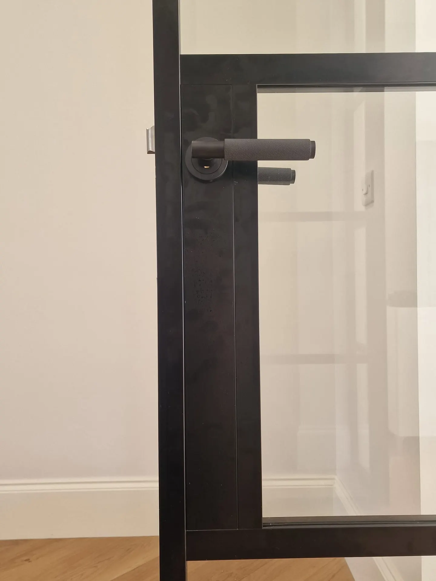Black lever handle on a steel-look internal door frame