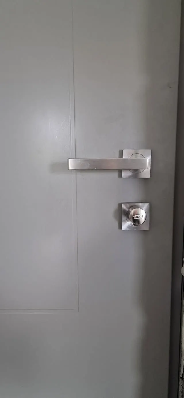 Lever handle and lock on a grey aluminium door